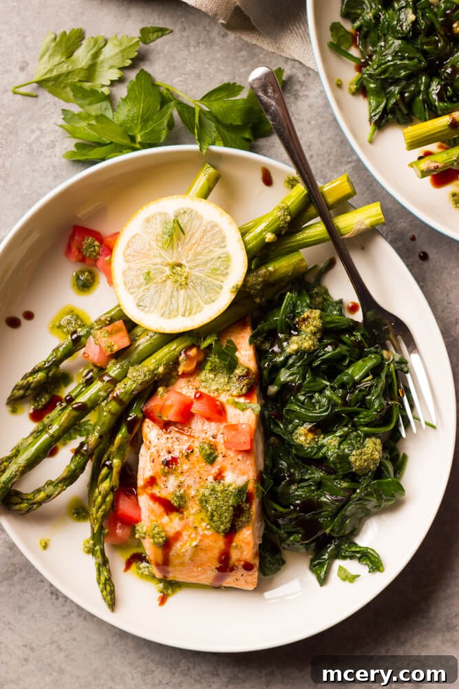 Individual serving of Baked Balsamic Salmon with asparagus and spinach on a plate.