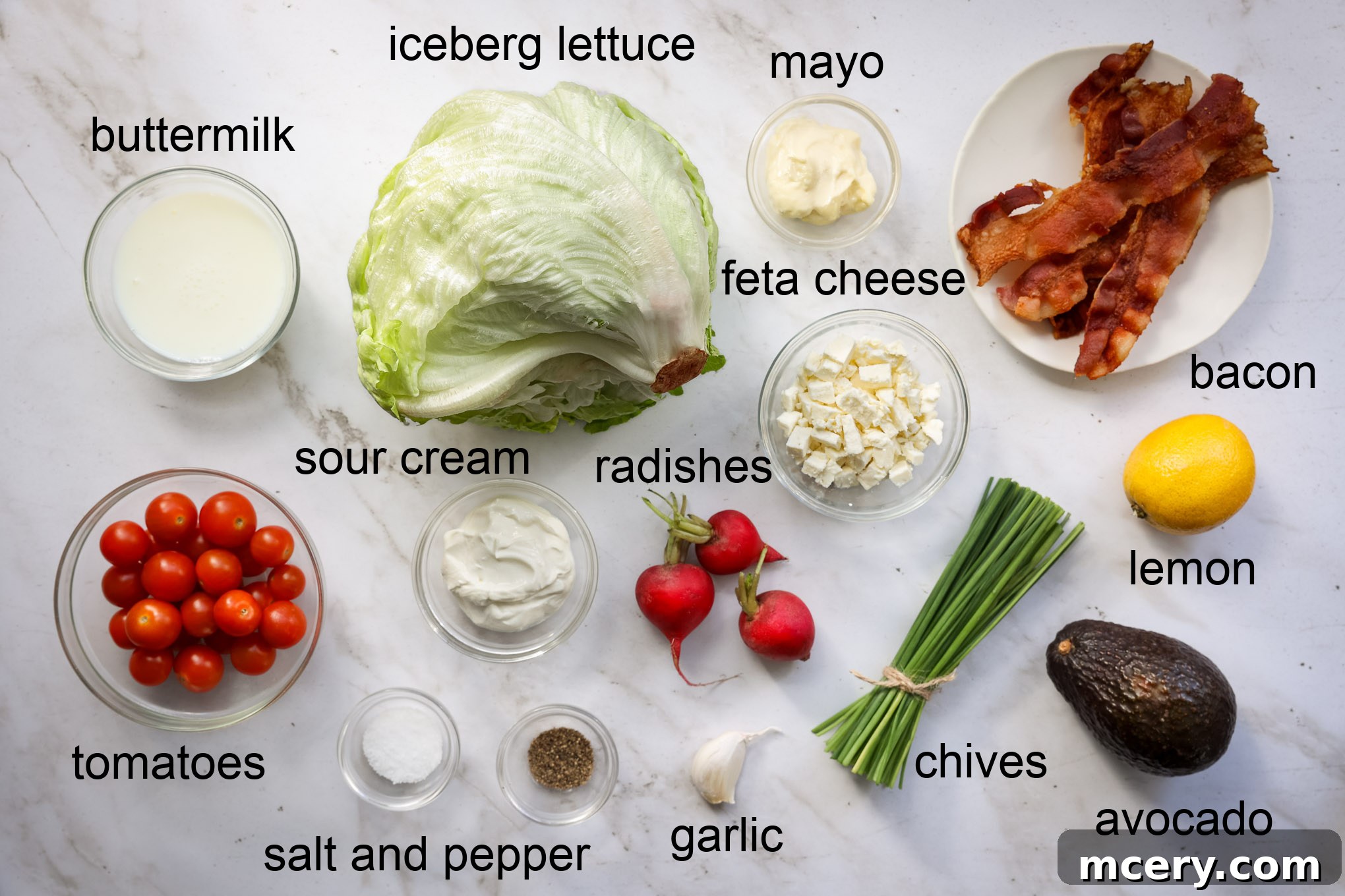 The Ultimate Chopped Wedge Salad 3 A vibrant selection of fresh ingredients for chopped wedge salad, including crisp iceberg lettuce, ripe tomatoes, creamy avocado, crisp radishes, and savory bacon, ready for preparation.