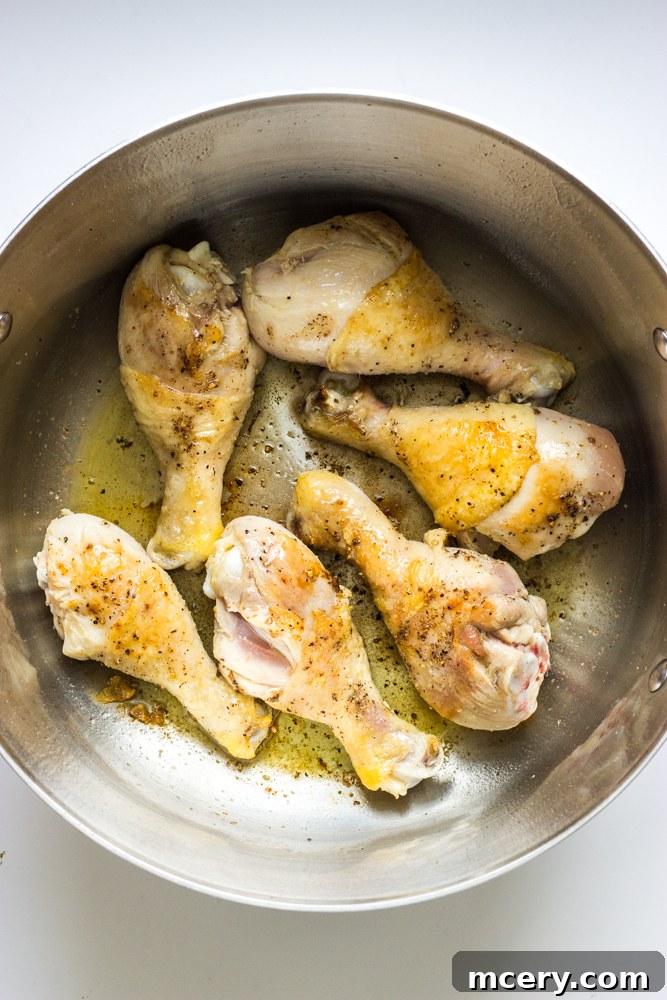 Simple Weeknight Chicken Cacciatore 5 seared chicken drumsticks inside a dutch oven.