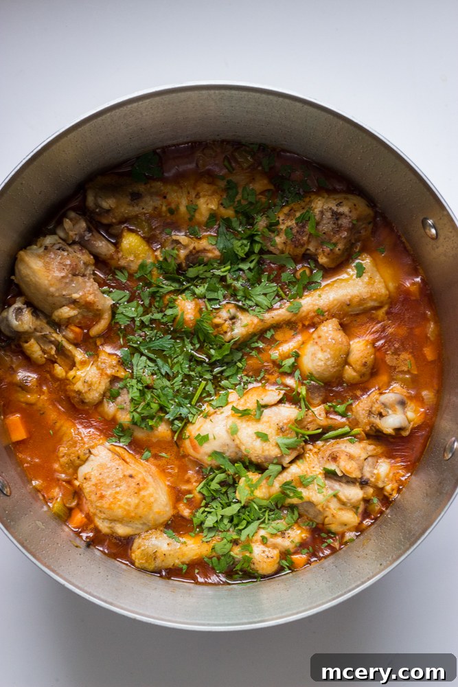 Simple Weeknight Chicken Cacciatore 9 cooked chicken drumsticks and vegetables in sauce garnished with chopped parsley.